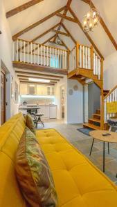 a living room with a yellow couch in the middle at Vilux with indoor private parking in Braşov