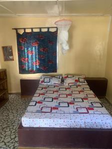 a bed with a quilt on it in a bedroom at Campement Ass Senghor in Toubakouta