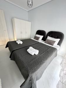 a bedroom with a large bed with two black chairs at Eden Suite Paralia in Paralia Katerinis