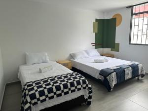 a room with two beds in a room at Hostal Pajuil in Armenia