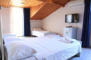 sypialnia z dwoma łóżkami i telewizorem na ścianie w obiekcie La Sorella Butik Hotel w mieście Ortaca