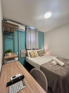 um pequeno quarto com duas camas e uma mesa em Mirante dos Corais em Porto de Galinhas