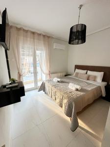 a bedroom with a bed and a large window at Eden Suite Paralia in Paralia Katerinis