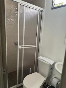 a small bathroom with a toilet and a shower at Hostal Pajuil in Armenia