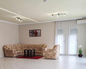 a living room with a couch and a table at Sunny City House Dunaújváros in Dunaújváros