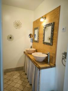 Baño con 2 lavabos y espejo en la pared en La Grange de Moisey, en Marigny-lès-Reullée