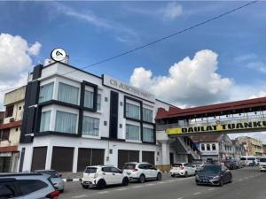 eine Stadtstraße mit Autos, die vor einem Gebäude geparkt sind in der Unterkunft CS Junction Point - Family Deluxe Room FDR in Kuala Pilah
