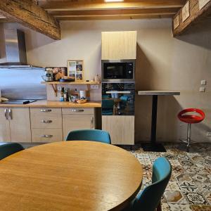 une cuisine avec une table en bois et des chaises bleues dans l'établissement Carcahouse, à Carcassonne