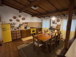 cocina con mesa de madera y nevera amarilla en B&B Casa Doria en Castelsardo