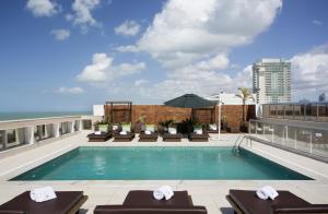 a swimming pool on the roof of a building at Royal Atlântica Macaé Hotel in Macaé