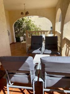 eine Terrasse mit Stühlen, Tischen und einem Torbogen in der Unterkunft Vista Xalo in Alcalalí