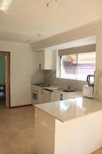 uma cozinha com electrodomésticos brancos e uma bancada em Comfort and Convenient em Perth
