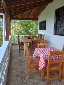 a patio with a table and chairs on a porch at Finca con vista al embalse y jacuzzi in Guatapé