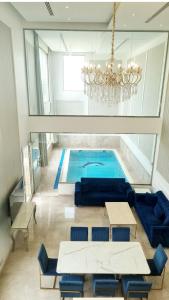 una piscina en una habitación con una lámpara de araña en شاليه المنى - الخبر - للعائلات, en Al Khobar