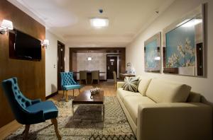 uma sala de estar com um sofá e uma mesa em Royal Atlântica Macaé Hotel em Macaé