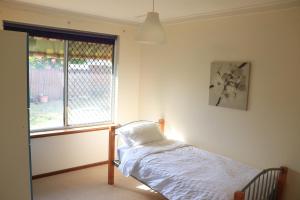 a bedroom with a bed and a window at Comfort and Convenient in Perth