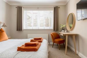 ein Schlafzimmer mit einem Bett, einem Spiegel und einem Stuhl in der Unterkunft Bournemouth Sea Views, 2 Bed, lift, close to shops in Bournemouth