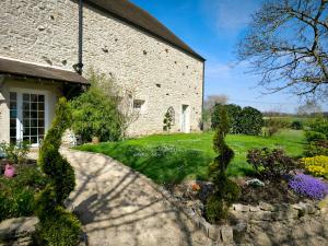 a stone house with a garden in front of it at La Grange de Moisey in Marigny-lès-Reullée