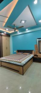 Cama en habitación con techo azul en Eco Living House- large group accommodation. en Varanasi