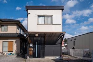 uma casa branca com uma garagem preta em Forest Agata em Matsumoto