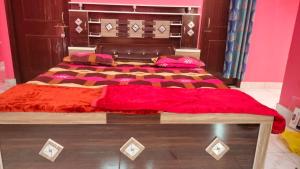 una camera da letto con un grande letto con una coperta rossa di Eco Living House- large group accommodation. a Varanasi