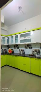 una cocina con armarios y encimeras verdes brillantes en Eco Living House- large group accommodation. en Varanasi