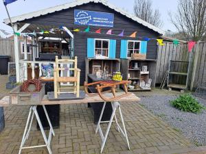 un edificio con un taller con muchos muebles de madera en Vakantie bij 17, en Serooskerke