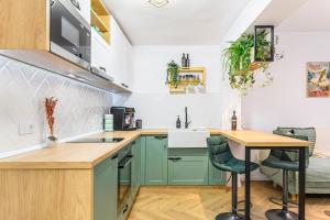 a kitchen with green cabinets and a table at Studio Guapo in Poiana Brasov