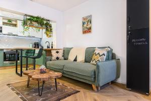 a living room with a green couch and a table at Studio Guapo in Poiana Brasov