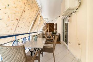einen Balkon mit einem Tisch, Stühlen und einer Kletterwand in der Unterkunft Modern Apartmen, Piraeus near Microlimano, Kastela in Piräus