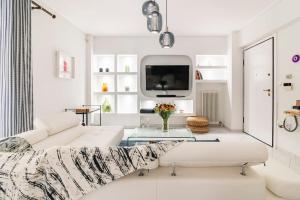 ein weißes Wohnzimmer mit einem Sofa und einem TV in der Unterkunft Modern Apartmen, Piraeus near Microlimano, Kastela in Piräus