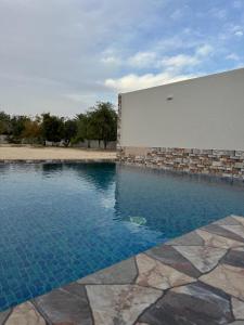 a swimming pool in front of a building at Rashed Farm in Al Rahba