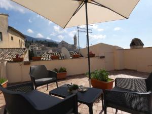 um pátio com cadeiras e um guarda-sol no telhado em Scappo in Umbria, La casa di Eude em Assis