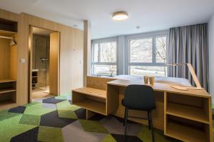 una camera con scrivania e letto e una camera da letto di The Lab Hotel & Apartments a Thun