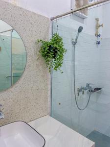 a bathroom with a sink and a shower with a plant at Nhà Của Bối - Villa Mộc Châu in Mộc Châu