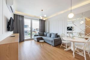 a living room with a couch and a table at Golden Apartment Prestige with Parking in Warsaw Bemowo in Warszawa