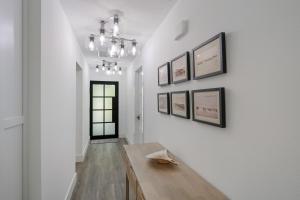 a hallway with a table and pictures on the wall at The Bea's Knees home in Anna Maria