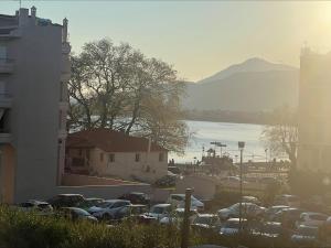 a parking lot with cars parked next to a body of water at NIKI APARTMENT 80 m2 IN GRIBOVO in Nafpaktos