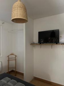 a living room with a couch and a tv on a wall at Appart'hôtel PrestigeHost in Orléans