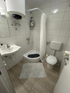 La petite salle de bains est pourvue de toilettes et d'un lavabo. dans l'établissement Studio apartman ANNI, Self CHECK-IN, à Osijek