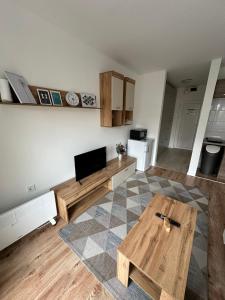 Il comprend un salon avec une table en bois et une cuisine. dans l'établissement Studio apartman ANNI, Self CHECK-IN, à Osijek