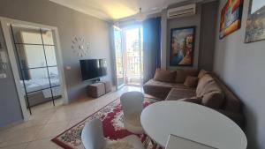 - un salon avec un canapé et une télévision dans l'établissement 6th floor Apartments, Apartament Tirana, à Tirana