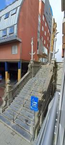 a blue sign in front of a building with stairs at 1-slaapkamer appartement - vlak bij strand - parkeerplaats inclusief in Blankenberge