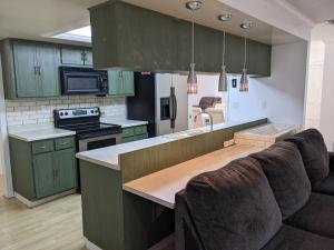 a kitchen with green cabinets and a couch in a room at Executive Pool Home in Tampa
