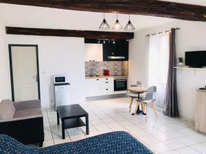 eine Küche und ein Wohnzimmer mit einem Tisch und Stühlen in der Unterkunft Studio douillet proche de la gare SNCF et du centre in Auxerre