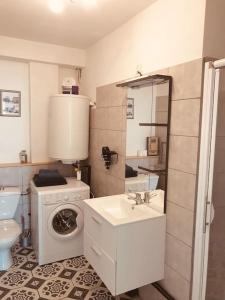 a bathroom with a washing machine and a washer at Studio douillet proche de la gare SNCF et du centre in Auxerre