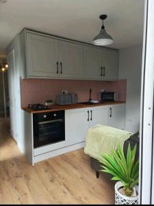 a kitchen with white cabinets and a stove at The Annex, Stratford Upon-Avon in Stratford-upon-Avon