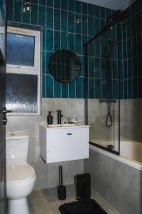 y baño con aseo, lavabo y ducha. en 6 Bed Modern Stay London N15 Close Links to Central London, en Londres