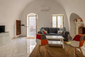 a living room with a couch and a table and chairs at Dimora Caravigna in Carovigno