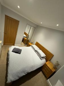 a bedroom with a large bed with white sheets at Town Centre 2 bedroom apartment in Wick